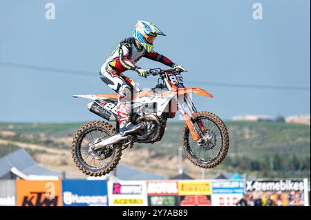 Agios Sozomenos, Chypre - 11 février 2024 : pilote de motocross portant un équipement de protection et conduisant un vélo tout-terrain puissant, volant dans les airs pendant un Banque D'Images