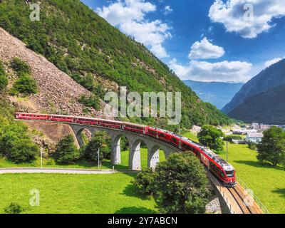 Vue aérienne d'un train Bernina Express traversant le viaduc en spirale Brusio du chemin de fer rhétique, canton des Grisons, Suisse Banque D'Images