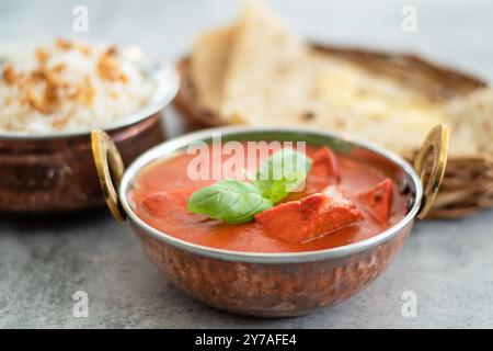 Poulet tikka masala nourriture épicée à la viande de curry beurre poulet avec riz et pain naan sur fond foncé gros plan. Poulet tikka masala avec riz et pourriture Banque D'Images