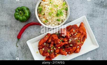 Délicieux poulet au gingembre miel-soja collant sur une assiette sur fond de pierre sombre. Recette asiatique, vue d'en haut. Espace de copie de la vue gros plan. Banque D'Images