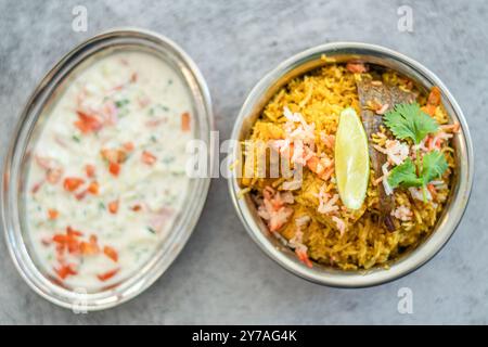 Épicé biryani pulao indien dans un bol doré avec plat de riz basmati Inde avec curry de viande de poulet Ramadan Kareem, Eid. Bol de service en laiton avec dos blanc Banque D'Images