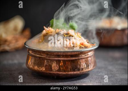 Biryani pulao indien fumé épicé dans un bol doré avec plat de riz basmati indien avec curry de viande de poulet Ramadan Kareem, Eid. Bol de service en laiton avec Whit Banque D'Images