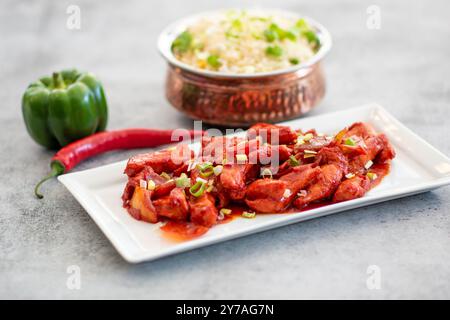 Délicieux poulet au gingembre miel-soja collant sur une assiette sur fond de pierre sombre. Recette asiatique, vue d'en haut. Espace de copie de la vue gros plan. Banque D'Images