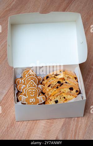 Biscuits au pain d'épices et biscotti soigneusement emballés dans une boîte blanche, parfaits pour les friandises de Noël. Banque D'Images