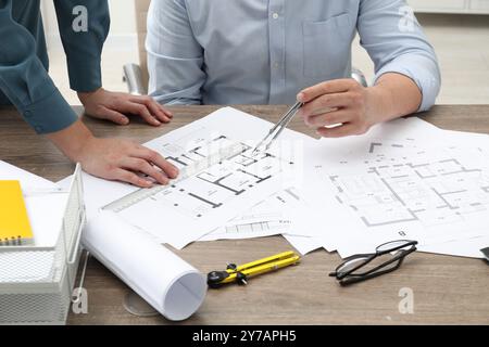 Architectes travaillant avec le projet, gros plan. Différents dessins techniques sur table en bois Banque D'Images