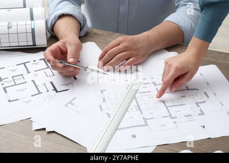 Architectes travaillant avec le projet, gros plan. Différents dessins techniques sur table en bois Banque D'Images