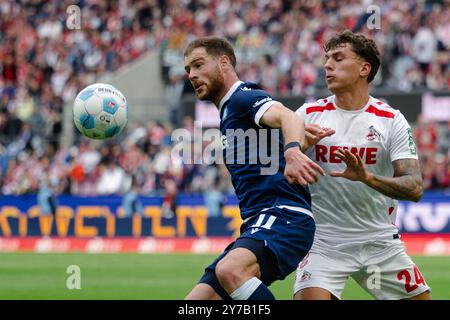 Cologne, Allemagne. 29 septembre 2024. Football : Bundesliga 2, 1. FC Köln - Karlsruher SC, Journée 7, RheinEnergieStadion. Julian Pauli de Cologne et Budu Zivzivadze de Karlsruhe se battent pour le ballon. Crédit : Marius Becker/dpa - NOTE IMPORTANTE : conformément aux règlements de la DFL German Football League et de la DFB German Football Association, il est interdit d'utiliser ou de faire utiliser des photographies prises dans le stade et/ou du match sous forme d'images séquentielles et/ou de séries de photos de type vidéo./dpa/Alamy Live News Banque D'Images