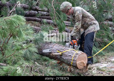 Jerry Chasteen, ingénieur de combat du 878th Engineer Battalion, 648th Maneuver Enhancement Brigade de la Garde nationale de Géorgie, basé à Augusta, coupe des branches d'arbres à Augusta, Géorgie, le samedi 28 septembre 2024. La Garde nationale géorgienne fournit un soutien en matière d'intervention et de rétablissement dans les zones touchées par l'ouragan Helene. En date de samedi soir, 975 000 clients des services publics en Caroline du Sud, 605,000 en Caroline du Nord, 677 000 en Géorgie et 289 000 en Floride sont restés sans électricité. Photo de SPC. Ayanna Tillman/U.S. Armée de la Garde nationale/UPI Banque D'Images