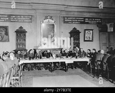 Vue de la salle de banquet où dînaient les chefs militaires américains et russes après la réunion des deux armées à Torgau, en Allemagne. Le bal est décoré de bannières russes et de photos de Staline et Roosevelt. Au centre se trouvent Gen. Countney Hodges, commandant général 1st U.S. Army, juste à gauche du miroir, (puis de gauche à droite) Gen. Jordov, commandant général de la 5e armée russe, Maj. Gen. William B. Kaan, chef d'état-major de la 1re armée américaine, Maj. Gen. Backenov, commandant général du 34e corps, armée russe, officier d'état-major russe et brigadier. Gen. Charles E. Hart, assistant au banquet après le M. Banque D'Images