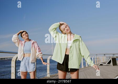 Jeune fille adulte et sa mère sportive senior faisant l'inclinaison de la tête sur le front de mer ensemble Banque D'Images