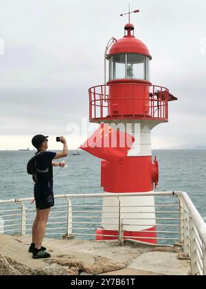 Hong Kong. 29 septembre 2024. Leung Chi Sum prend des photos près d'un phare dans le district de Yantian à Shenzhen, dans la province du Guangdong au sud de la Chine, le 22 avril 2023. TO GO WITH' Feature : le 'Running Man' de Hong Kong : célébrer le patriotisme avec le drapeau national chinois' crédit : Xinhua/Alamy Live News Banque D'Images