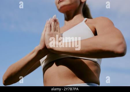 Gros plan moyen de mains manucurées féminines méconnaissables dans la posture de Pranamasana Banque D'Images