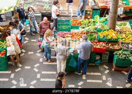 Les gens qui achètent des fruits et légumes frais au Mercado dos Lavradores ou au marché fermier de Funchal sur l’île portugaise de Madère Banque D'Images