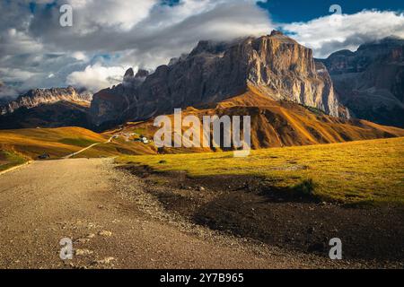 Route rurale sur la pente et crête de montagne fantastique en arrière-plan, groupe de montagnes Sella, Dolomites, Italie, Europe Banque D'Images