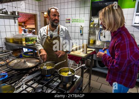 Le chef René Bobzin prépare du poisson désossé avec divers plats de pommes de terre dans la cuisine du Bauernstube de Bobzin et les présente personnellement à la table des convives. Dewichower Straße, Usedom-Süd, Mecklembourg-Poméranie occidentale, Allemagne Banque D'Images