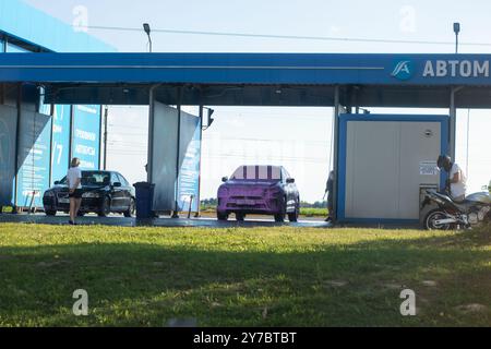 Biélorussie, Minsk - 18 juillet 2024 : devant un bâtiment qui affiche en évidence le mot abtom, il y a une voiture violette frappante garée, ajoutant vibrant Banque D'Images