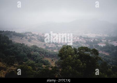 Une vue panoramique sur le village de Monsanto, Portugal, comme le brouillard roule dans la vallée, couvrant le paysage dans une couverture sereine et mystique. Banque D'Images