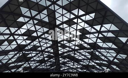 Un détail architectural frappant mettant en valeur une structure de plafond moderne en verre et en acier. Le motif complexe de lignes et de triangles qui se croisent crée Banque D'Images