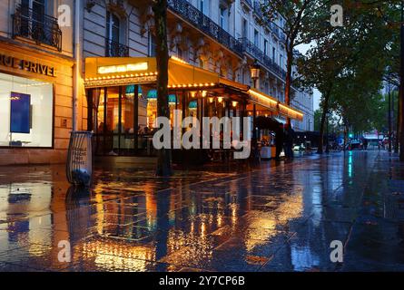 Le traditionnel café français de Paris au soir de pluie. Il est situé près de l'Arc de Triomphe à Paris. Banque D'Images