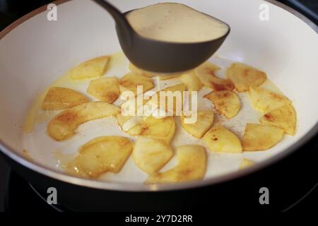 Cuisine souabe, préparation faire frire des morceaux de pomme, mettre la pâte crue dans la poêle, louche à soupe, crêpe à la pomme, Flaedle, cannelle, croustillant aux pommes avec glace à la lavande Banque D'Images