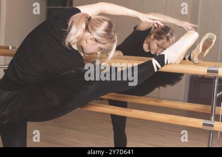 Ballerine en vêtements noirs s'exerce dans le studio de danse. femme en tutu et en chaussures de pointe dans un cours de danse Banque D'Images