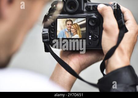 Reflex appareil photo dans les mains. Prise de vue photographe mains close up. L'homme est photographe pour photos stock photography. Tenir les mains des hommes Banque D'Images