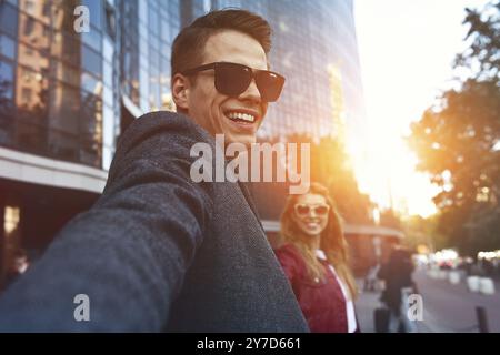 Beau jeune couple aimant portant des sacs à provisions et jouissant ensemble. Photo montrant un jeune couple faisant du shopping dans la ville Banque D'Images