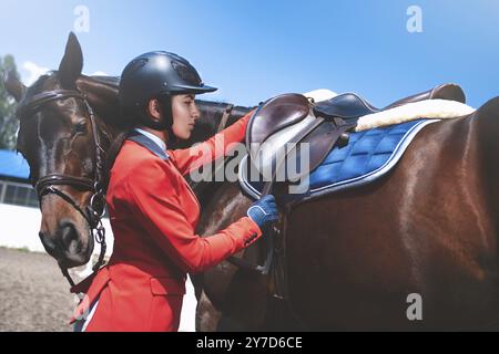 Fille ajuste jockey sur son cheval de selle de prendre part à des courses de chevaux Banque D'Images