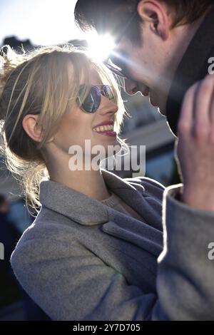 Heureux couple ludique dans des lunettes de soleil dans l'amour datant blague et rire dans la rue Banque D'Images