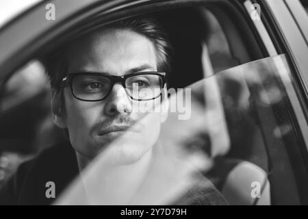 Profitez de la conduite. Image d'un jeune beau gars assis dans la voiture Banque D'Images