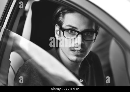 Profitez de la conduite. Image d'un jeune beau gars assis dans la voiture Banque D'Images