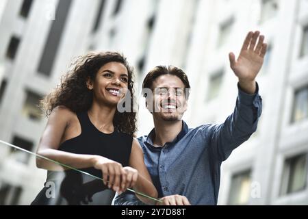 Heureux couple international avoir une conversation en ville. Femme mixte et homme caucasien Banque D'Images