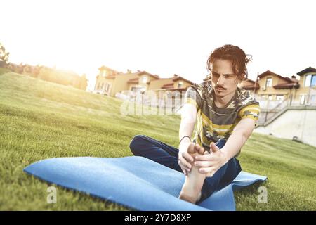 Yoga fitness homme jeune homme faire de l'exercice en plein air Banque D'Images