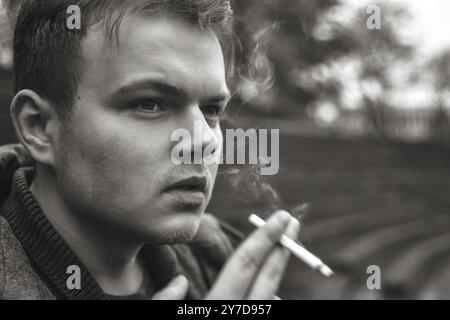 Guy fume une cigarette à l'extérieur, portrait, close-up Banque D'Images