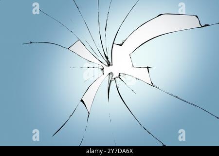 Verre cassé sur fond bleu, fissures dans le verre, fond abstrait avec un trou au centre Banque D'Images