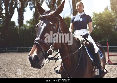 Portrait Jockey Girl à côté d'un cheval, équitation, concept de publicité d'un club équestre, préparation pour les sauts. Été Banque D'Images