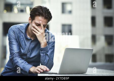 Homme d'affaires stressé après l'échec du projet. Confus jeune homme frustré par un problème en ligne Banque D'Images