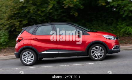 Milton Keynes, Royaume-Uni - 29 septembre 2024 : 2017 voiture Renault Captur à moteur diesel rouge conduisant sur une route britannique Banque D'Images