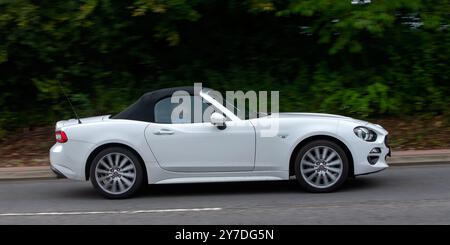 Milton Keynes, Royaume-Uni - 29 septembre 2024 : 2016 voiture blanche Fiat 124 Spider Lusso conduisant sur une route britannique Banque D'Images