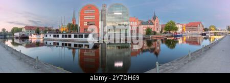 Vue panoramique sur le front de mer de Bydgoszcz au crépuscule, montrant des bâtiments historiques et modernes le long de la rivière Brda en Pologne Banque D'Images