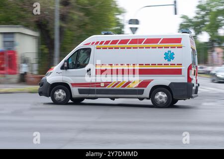 Manœuvrant rapidement à travers les rues de la ville, l'ambulance se précipite pour aider Banque D'Images