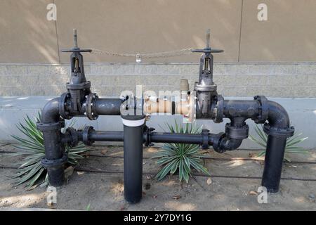 Un regard détaillé sur les différentes vannes de prévention de refoulement et les systèmes de sécurité incendie installés autour d’un site industriel. Banque D'Images