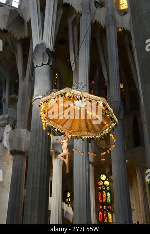 Statue crucifiée de Jésus Christ au-dessus de l'autel dans la basilique de la Sagrada Familia à Barcelone, Catalogne, Espagne Banque D'Images