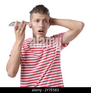 Jeune homme avec smartphone écoutant un message vocal sur fond blanc Banque D'Images