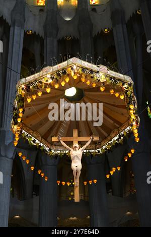 Statue crucifiée de Jésus Christ au-dessus de l'autel dans la basilique de la Sagrada Familia à Barcelone, Catalogne, Espagne Banque D'Images