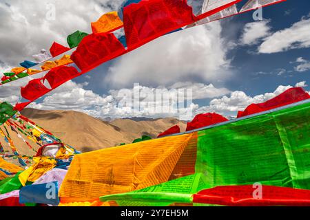SHIGATSE, TIBET - 1er AOÛT 2022 : des drapeaux de prière tibétains colorés flottent au sommet du col de Kardung la en Inde, l'un des plus hauts cols de montagne motorisables Banque D'Images