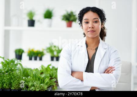 Science, confiance et portrait de femme avec des plantes pour le développement d'ogm, la croissance ou l'étude de recherche en laboratoire. Vert, feuilles et scientifique biotech avec Banque D'Images