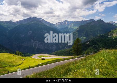 Célèbre route alpine sinueuse grossglockner à travers les montagnes. Petite maison en bois se dresse à l'un des virages. Montagnes majestueuses au loin. Austr Banque D'Images