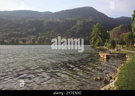 Monasterolo al Castello, Italie - août 2024 - les gens se promènent au bord du lac au coucher du soleil Banque D'Images