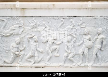 Vue rapprochée d'une ancienne scène de combat et de bataille sur la frise de marbre élaborée. À la tour commémorative de la Révolution en marbre blanc à Vientiane, Laos. Banque D'Images